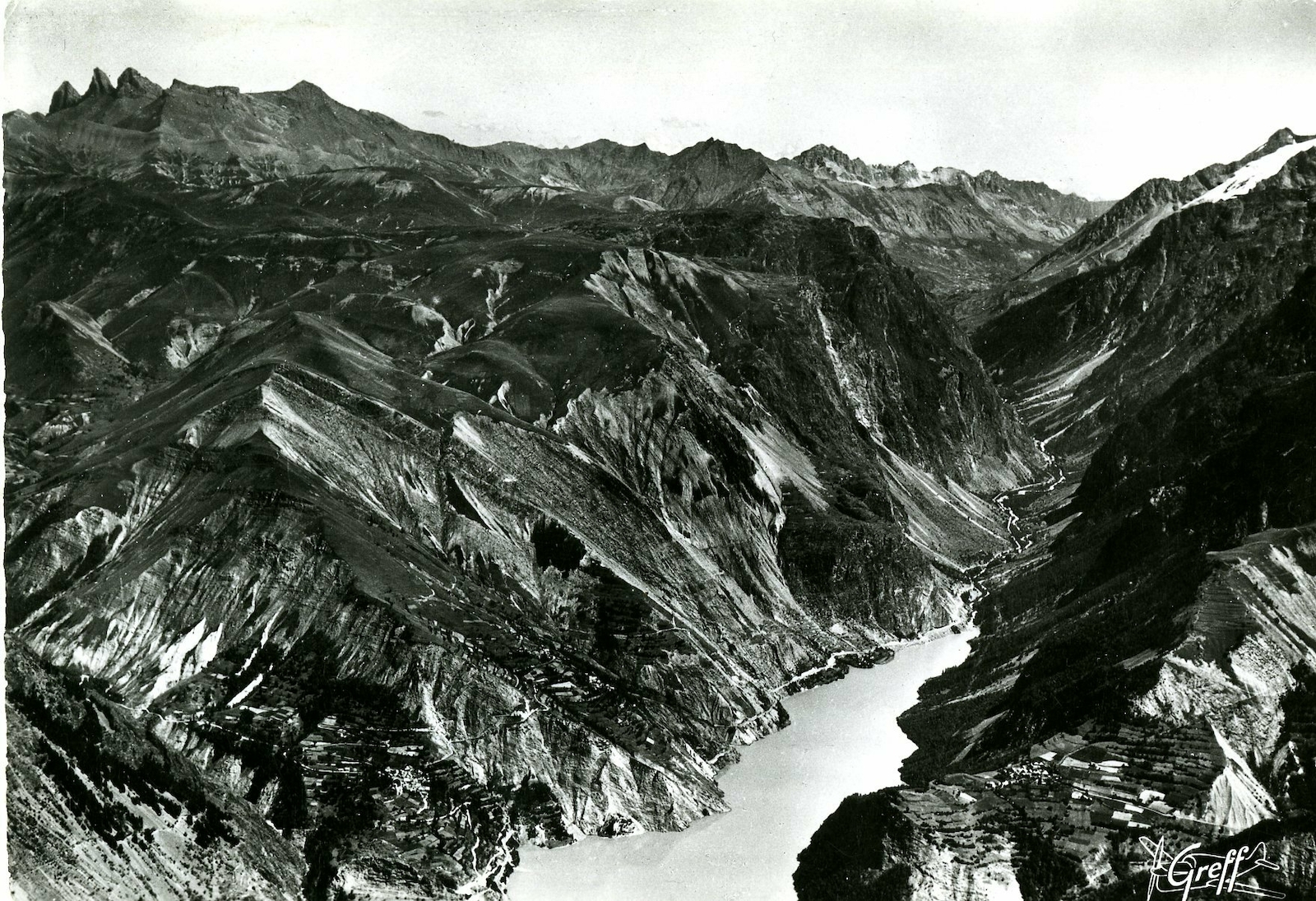 Une vue aérienne majestueuse du lac du Chambon et de ses environs, mettant en valeur les montagnes environnantes, ainsi 